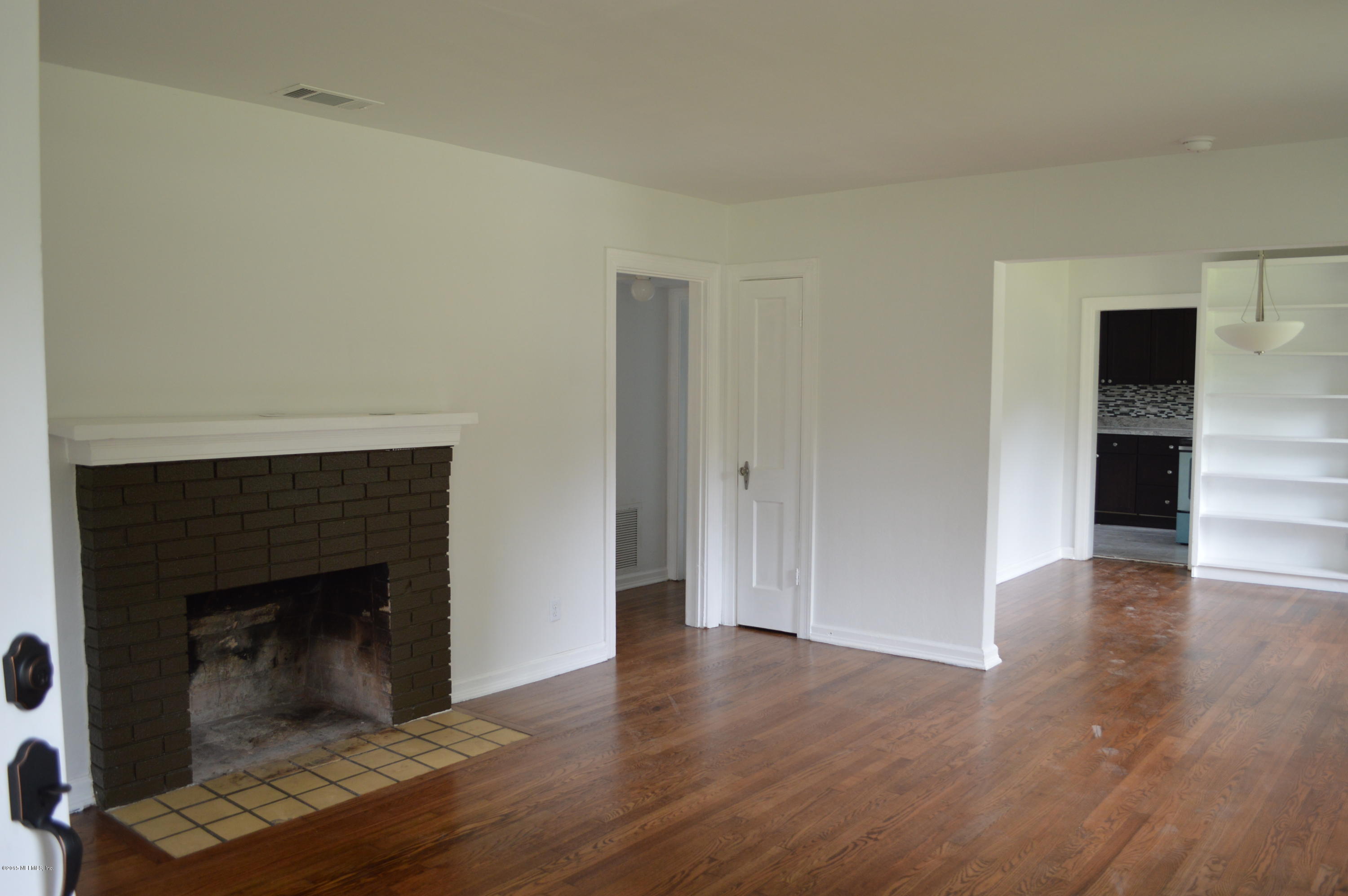 4603 Sunderland Road Jacksonville, FL 32210 - Photo 9 of 20 a view of a livingroom with wooden floor and a fireplace