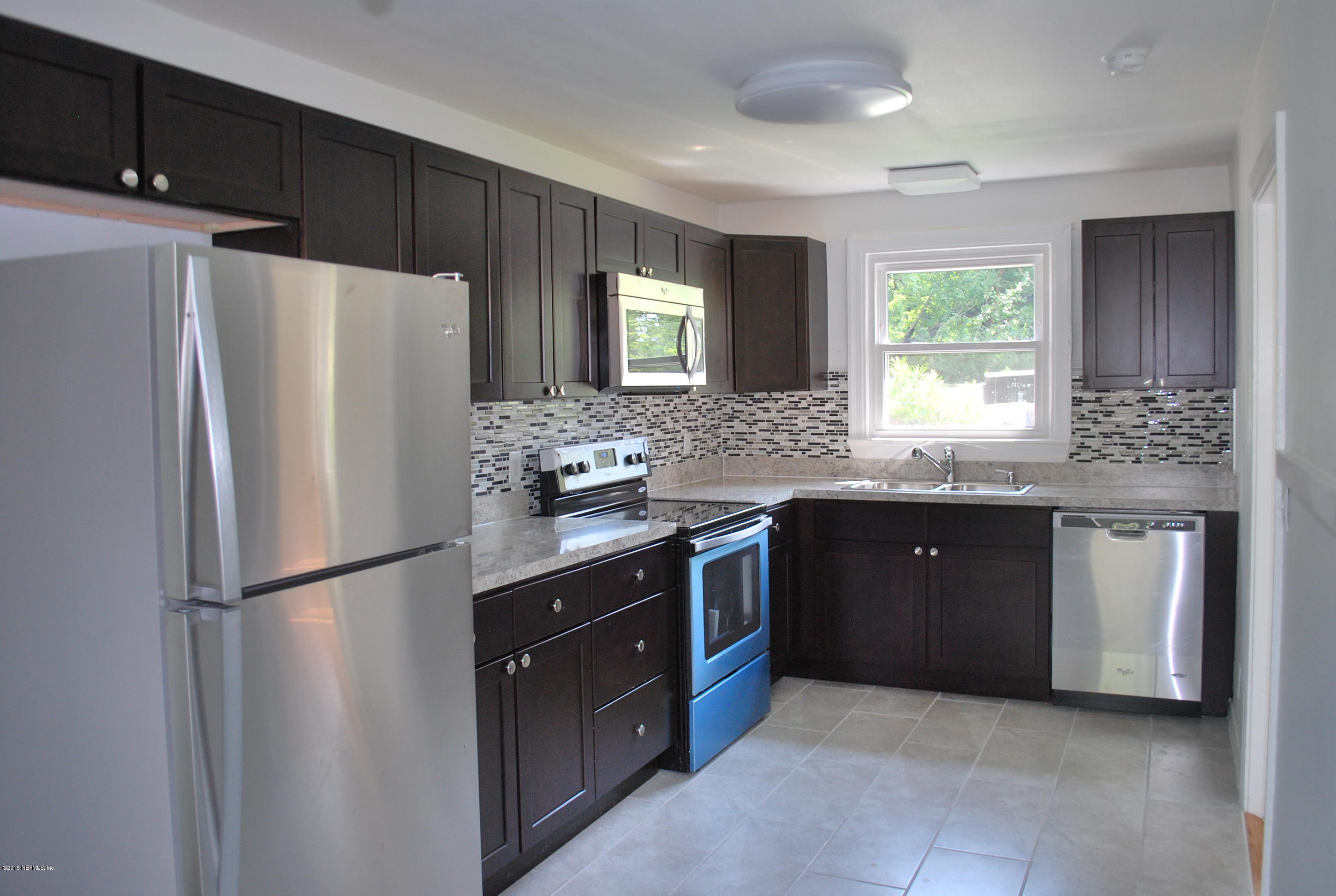 4603 Sunderland Road Jacksonville, FL 32210 - Photo 10 of 20 a kitchen with granite countertop a refrigerator and a sink