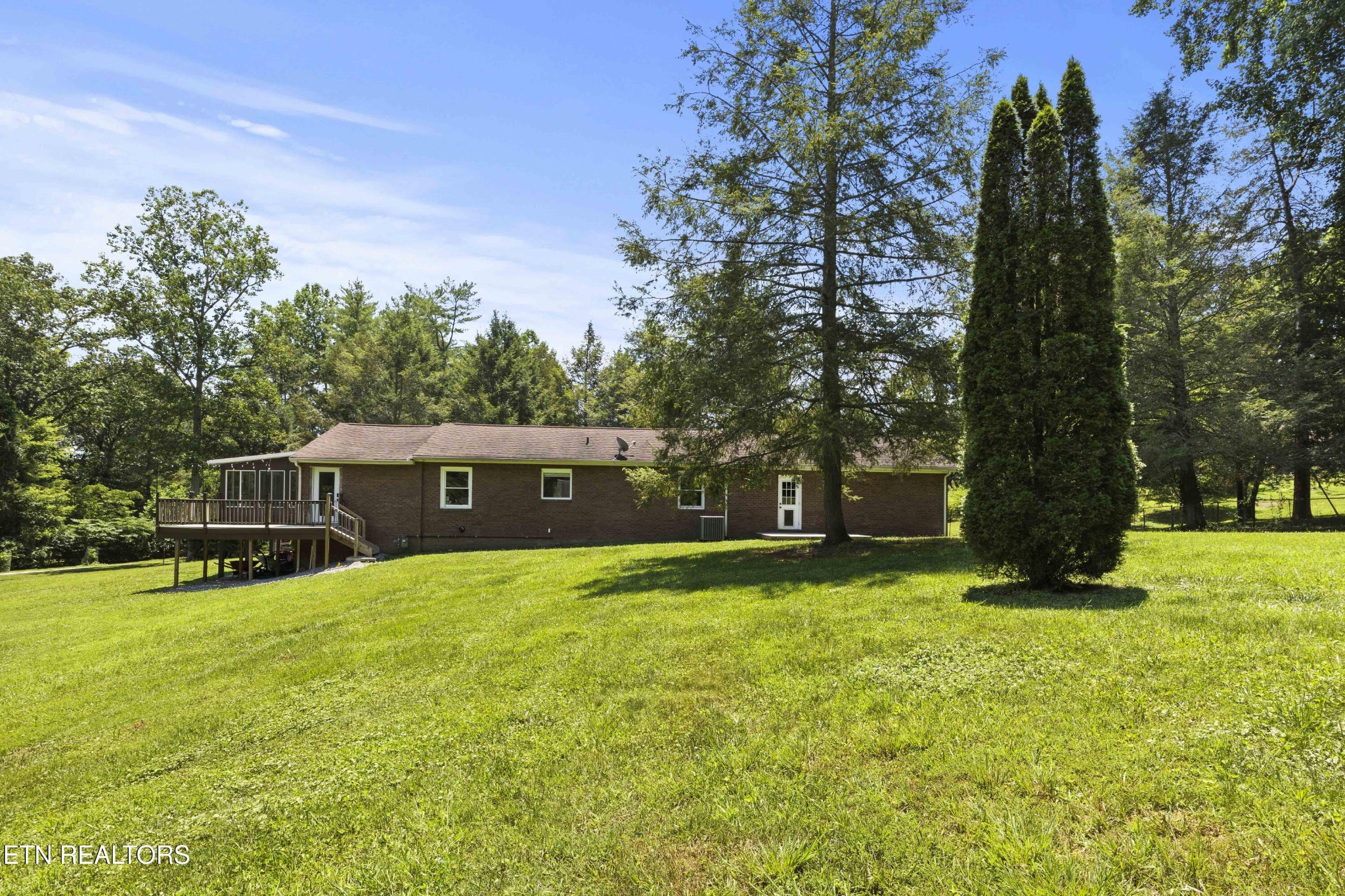 99 Reservoir Road Norris, TN 37828 - Photo 36 of 47 a backyard of a house with large trees and plants