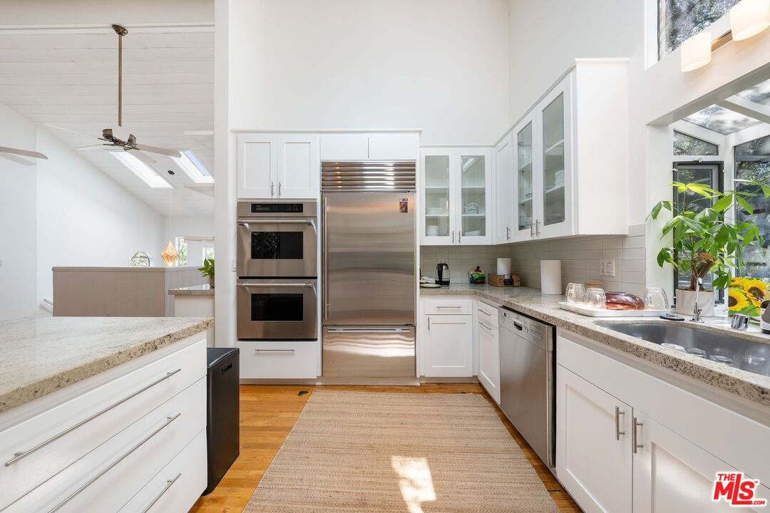 22760 Chamera Lane Topanga, CA 90290 - Photo 15 of 52 a kitchen with stainless steel appliances granite countertop a refrigerator and a sink