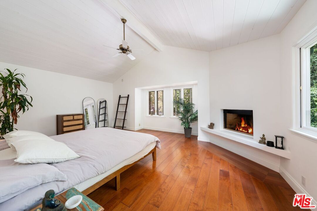 22760 Chamera Lane Topanga, CA 90290 - Photo 46 of 52 a bedroom with a bed and a fireplace
