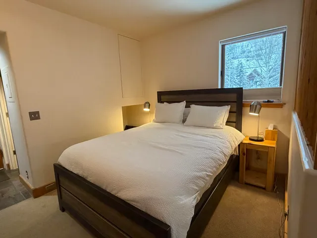 a bed sitting in a bedroom next to a window