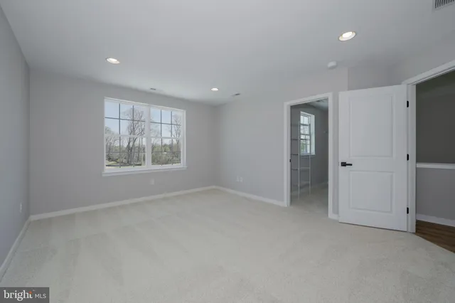 an empty room with windows and closet