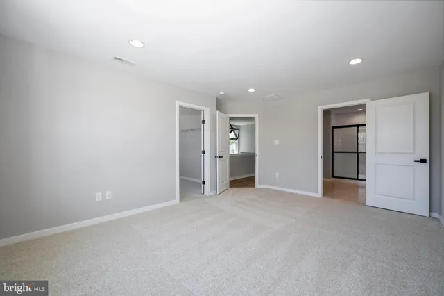 an empty room with closet and windows