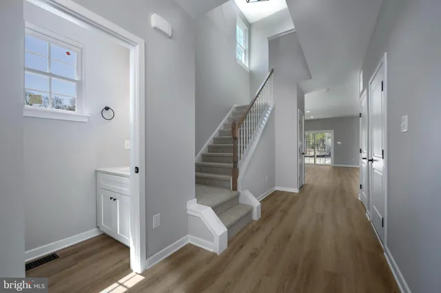 a view of a hallway with wooden floor and staircase