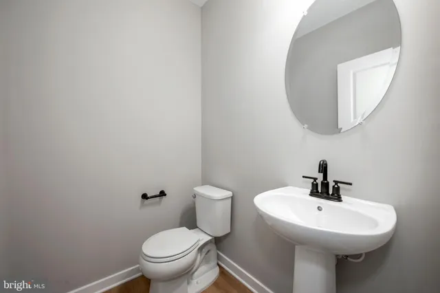 a bathroom with a sink a mirror and toilet