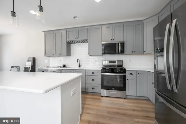 a kitchen with stainless steel appliances a refrigerator sink and microwave
