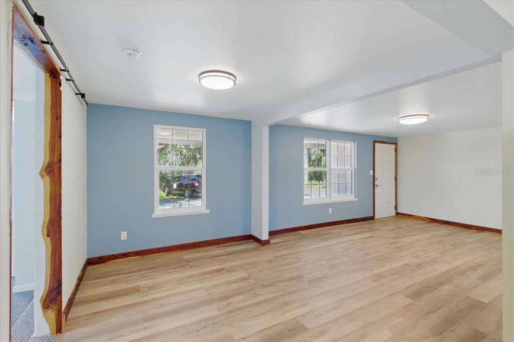 12301 Cedar Street Cedar Key, FL 32625 - Photo 11 of 38 a view of an empty room with wooden floor and a window