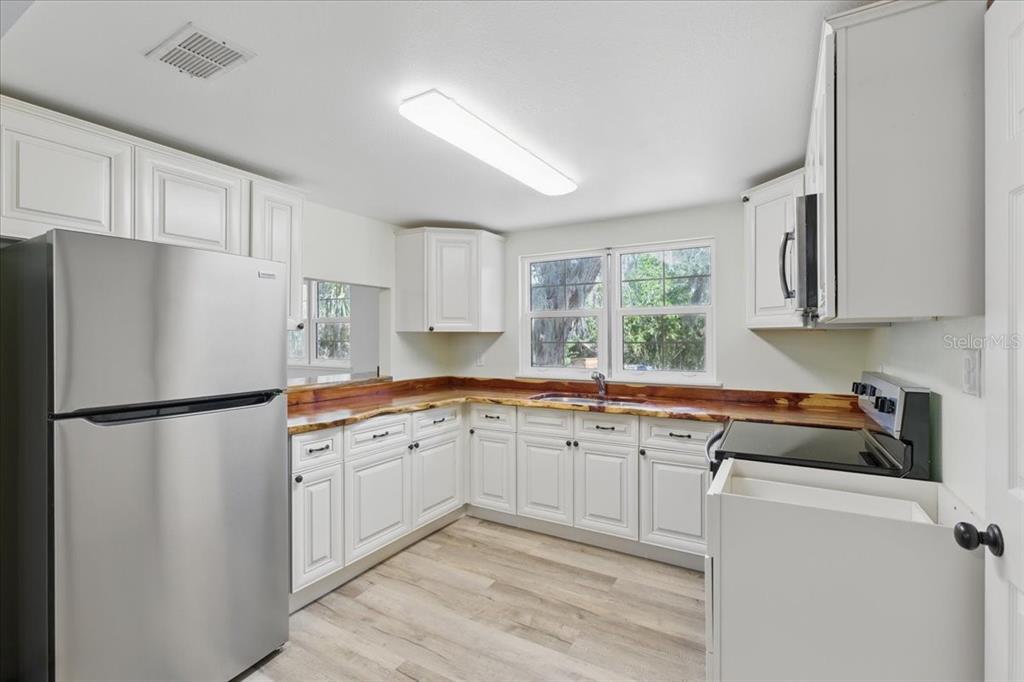 12301 Cedar Street Cedar Key, FL 32625 - Photo 12 of 38 a kitchen with a refrigerator a sink and cabinets