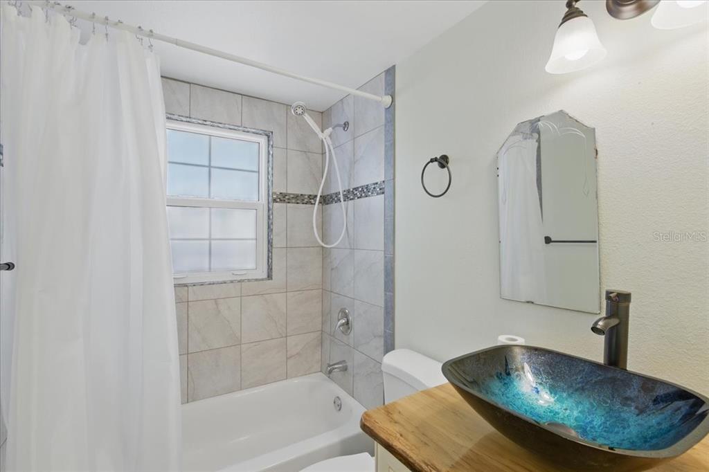 12301 Cedar Street Cedar Key, FL 32625 - Photo 24 of 38 a bathroom with a tub shower vanity and a sink