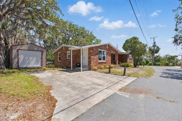 a front view of house with yard and trees around
