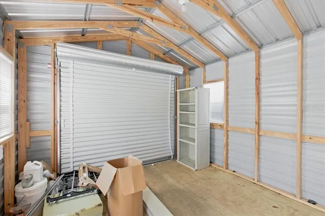 a view of a small house with backyard and trees