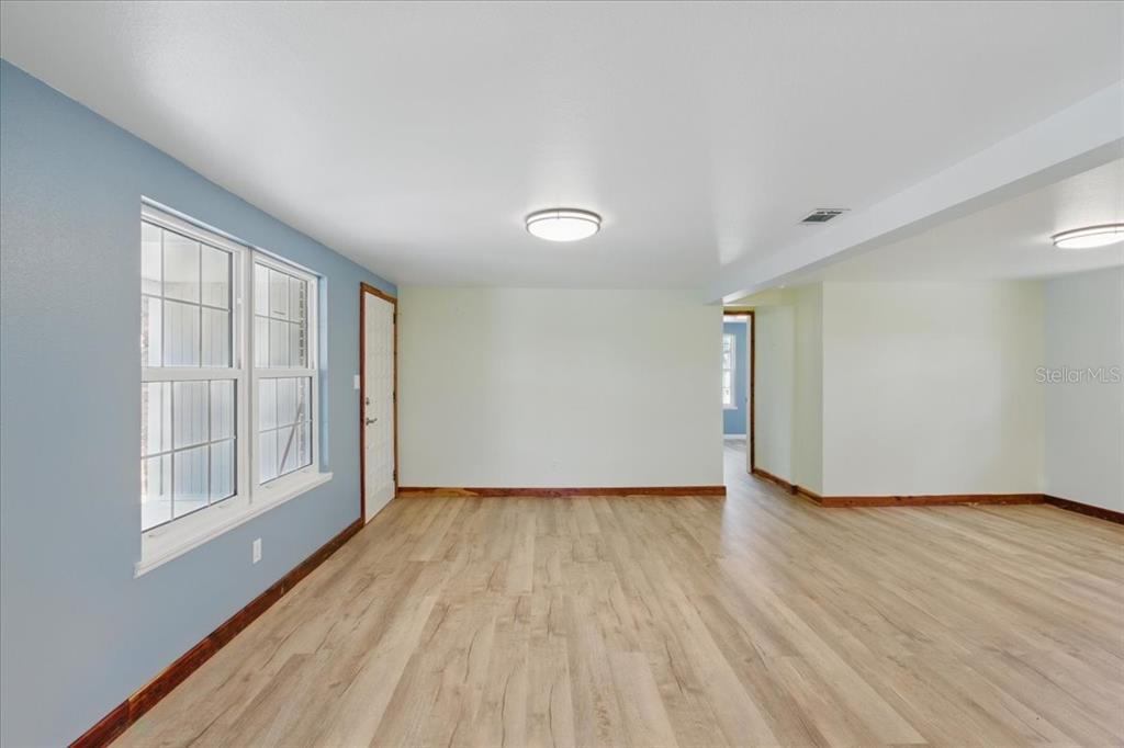 12301 Cedar Street Cedar Key, FL 32625 - Photo 9 of 38 a view of an empty room with wooden floor and a window