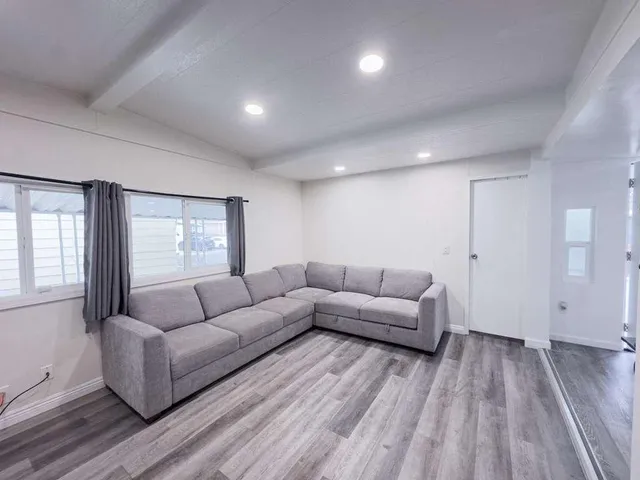 a living room with furniture and a hard wood floor