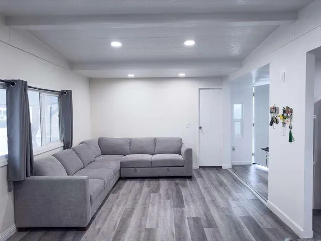 a living room with furniture and wooden floor