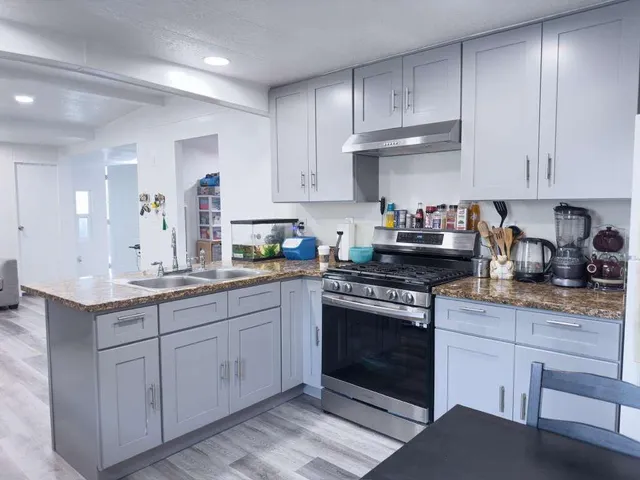 a kitchen with granite countertop cabinets stainless steel appliances and a sink