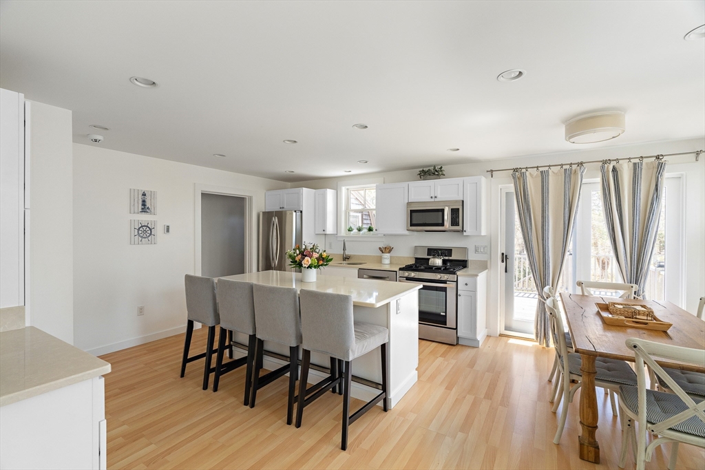 13 Young Street Edgartown, MA 02539 - Photo 4 of 29 a kitchen with stainless steel appliances a dining table chairs stove refrigerator and cabinets