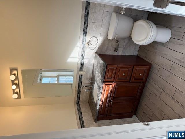 600 Frank E Rodgers Boulevard North, Unit 3 Harrison, NJ 07029 - Photo 10 of 16 a bathroom with a granite countertop toilet sink and mirror
