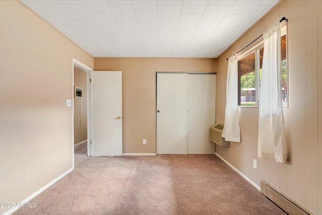 a bedroom with a bed and painting on the wall