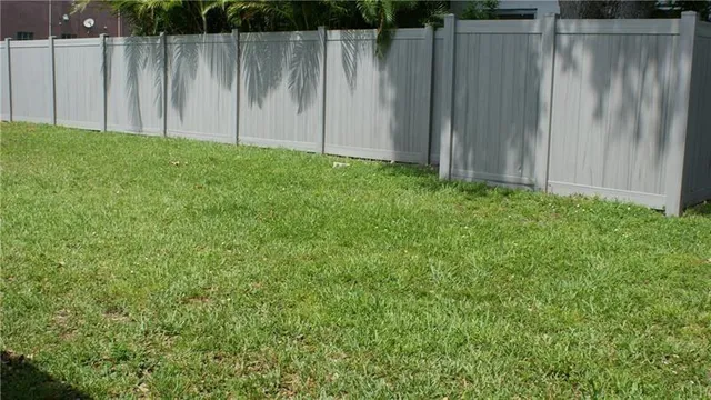 a view of a backyard with wooden fence