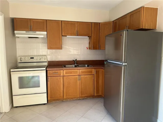 a kitchen with a refrigerator sink and cabinets