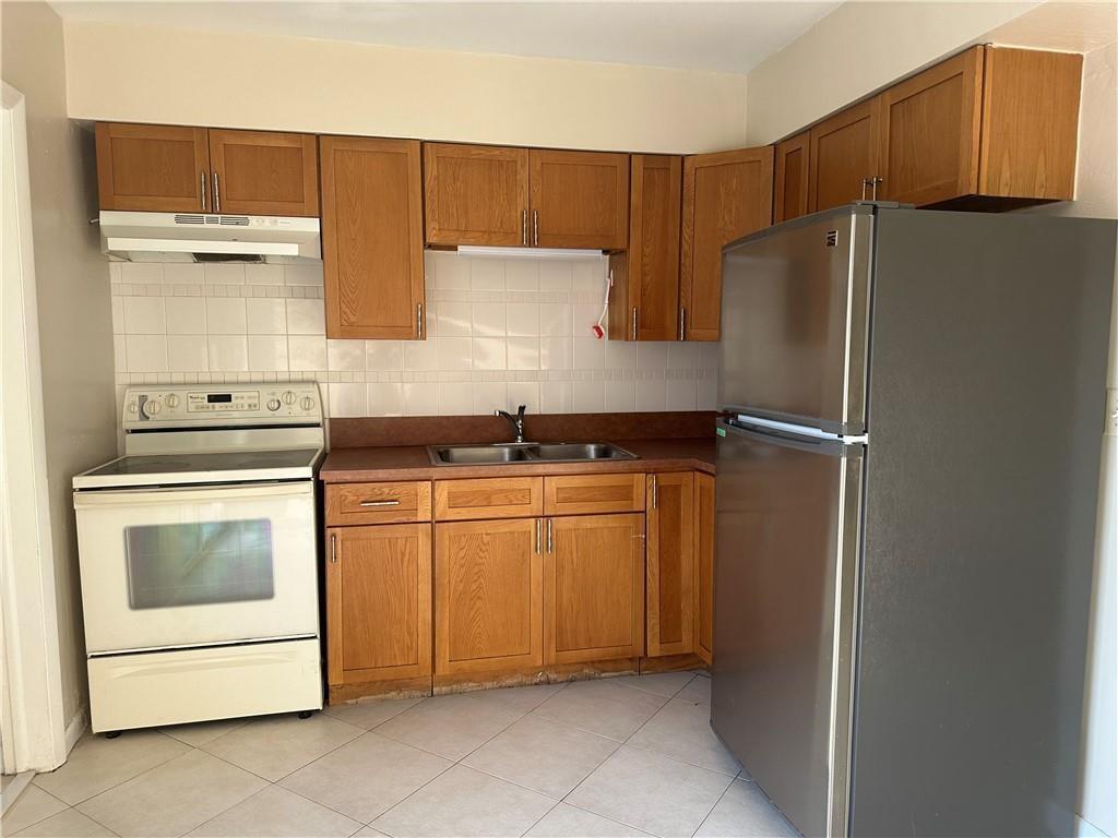 6109 Southwest 30th Street, Unit 1 Miramar, FL 33023 - Photo 7 of 11 a kitchen with a refrigerator sink and cabinets