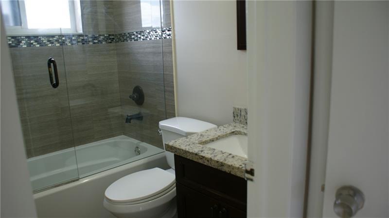 6109 Southwest 30th Street, Unit 1 Miramar, FL 33023 - Photo 8 of 11 a bathroom with a granite countertop bathtub shower sink vanity and toilet