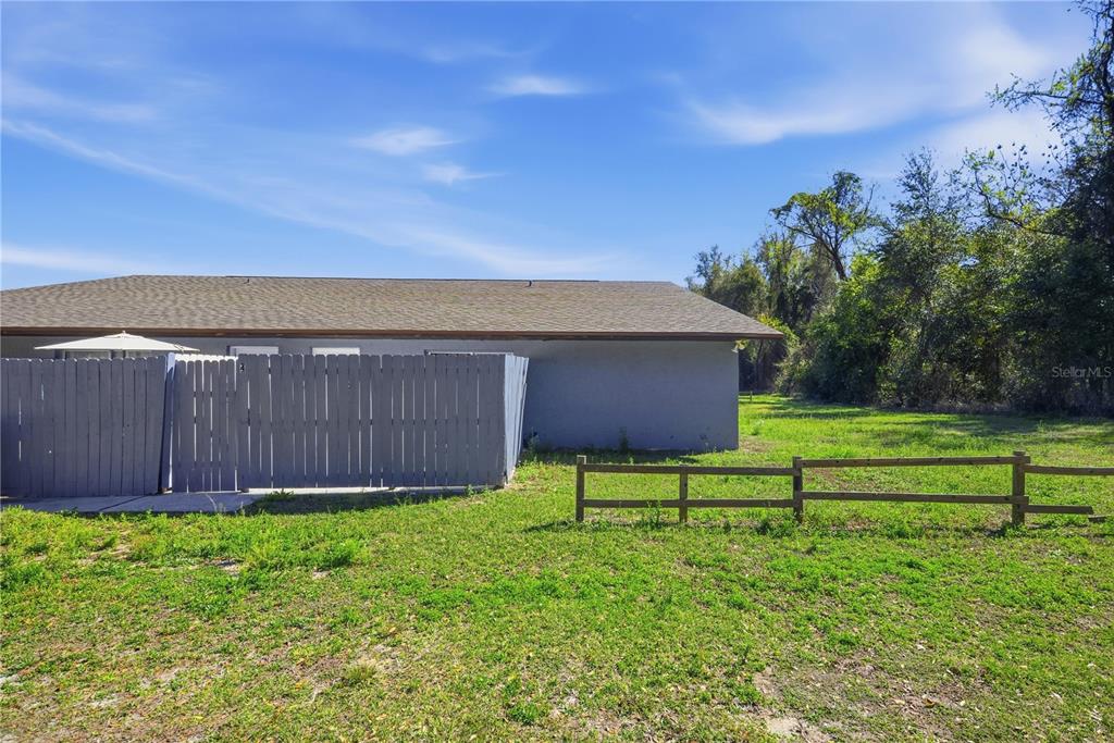 1836 Southwest 109th Place Ocala, FL 34476 - Photo 3 of 16 a view of a chair under an umbrella in front of house