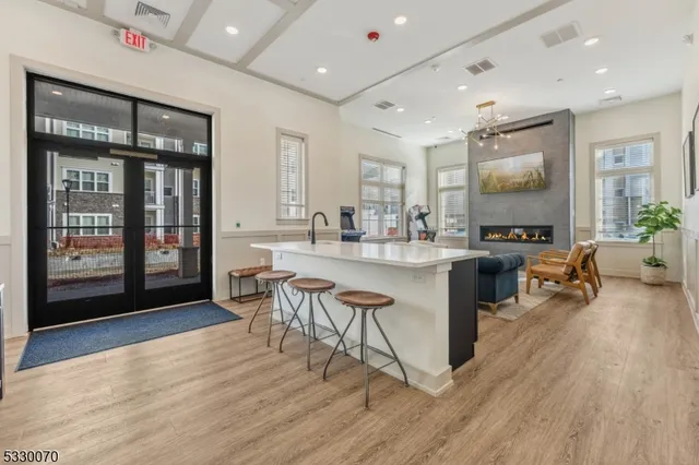 a kitchen with a sink dishwasher a stove and a dining table with wooden floor