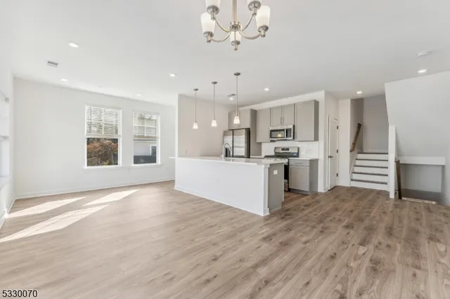 a view of kitchen with granite countertop cabinets and refrigerator