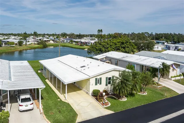 an aerial view of a house with a garden and lake view
