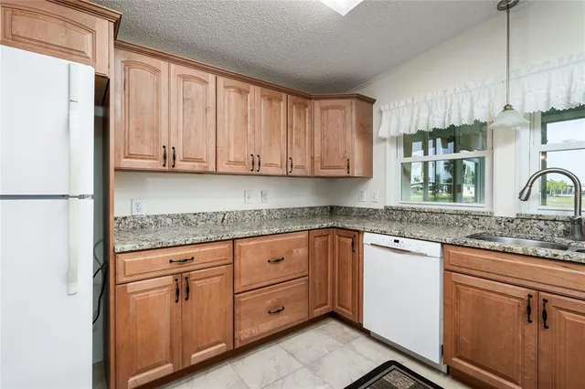 a kitchen with stainless steel appliances granite countertop a refrigerator sink and cabinets