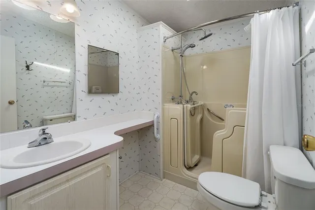 a bathroom with a granite countertop sink toilet and shower