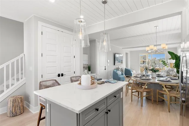 a view of a a dining room and livingroom with furniture wooden floor a chandelier