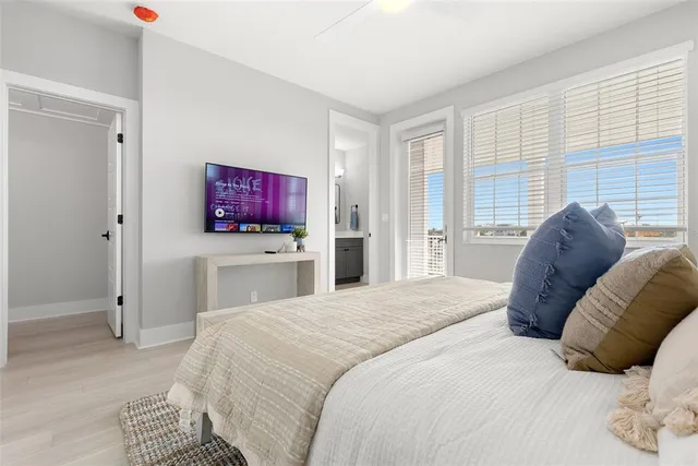 a bedroom with a large bed and a flat tv screen