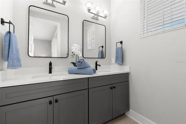 a bathroom with a double vanity sink and a mirror