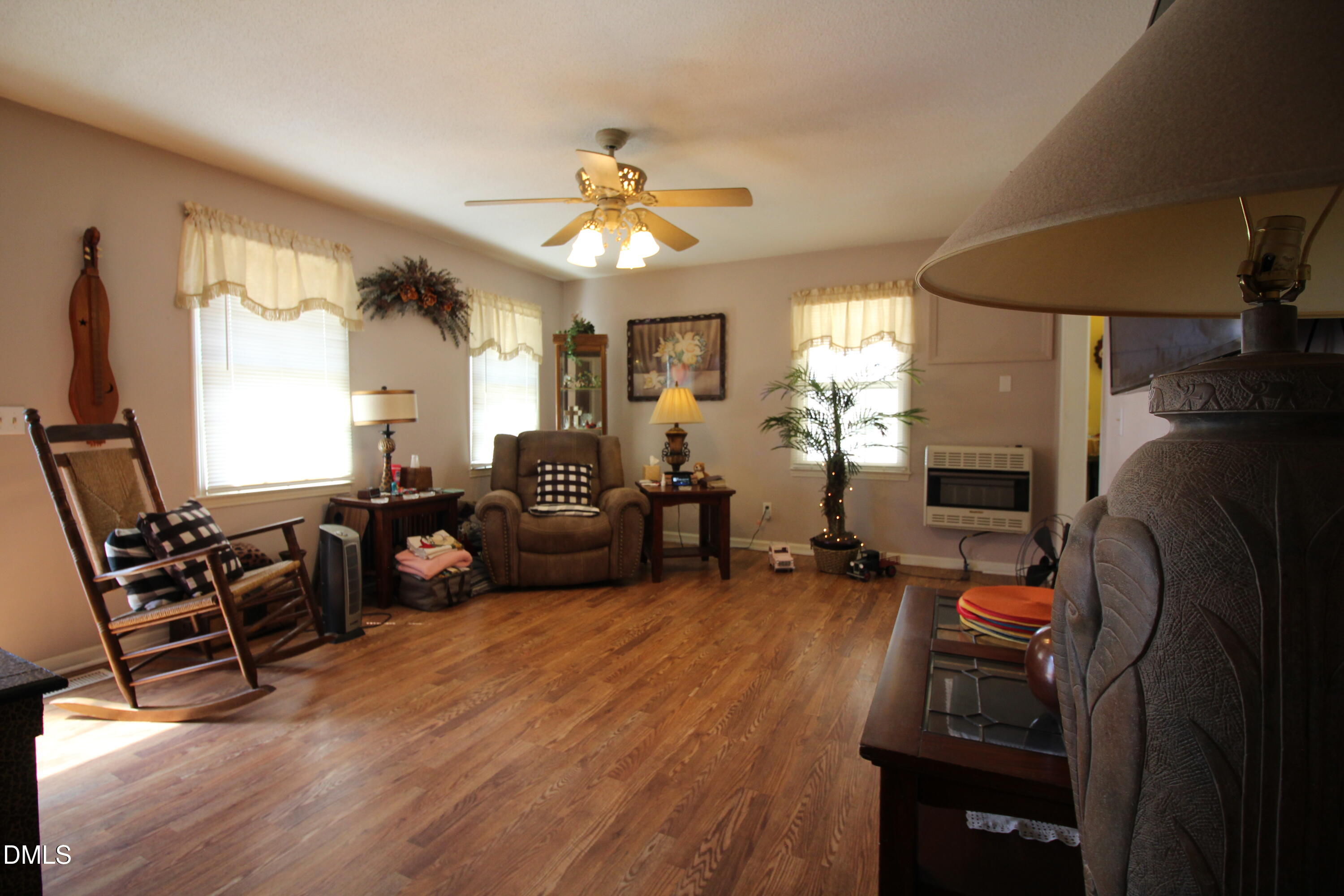 56 Ash Street Coats, NC 27521 - Photo 20 of 28 a living room with furniture a flat screen tv and a fireplace
