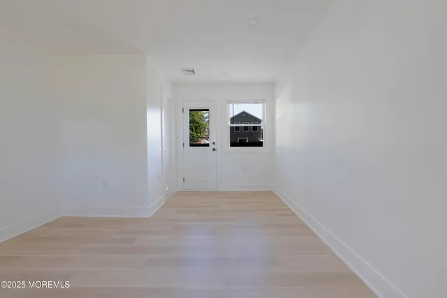 an empty room with windows and mirror