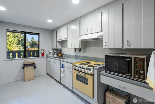 a kitchen with granite countertop a stove top oven
