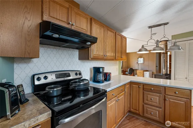 a kitchen with stainless steel appliances granite countertop a sink stove and cabinets