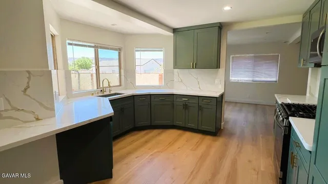 a kitchen with a sink and wooden floor