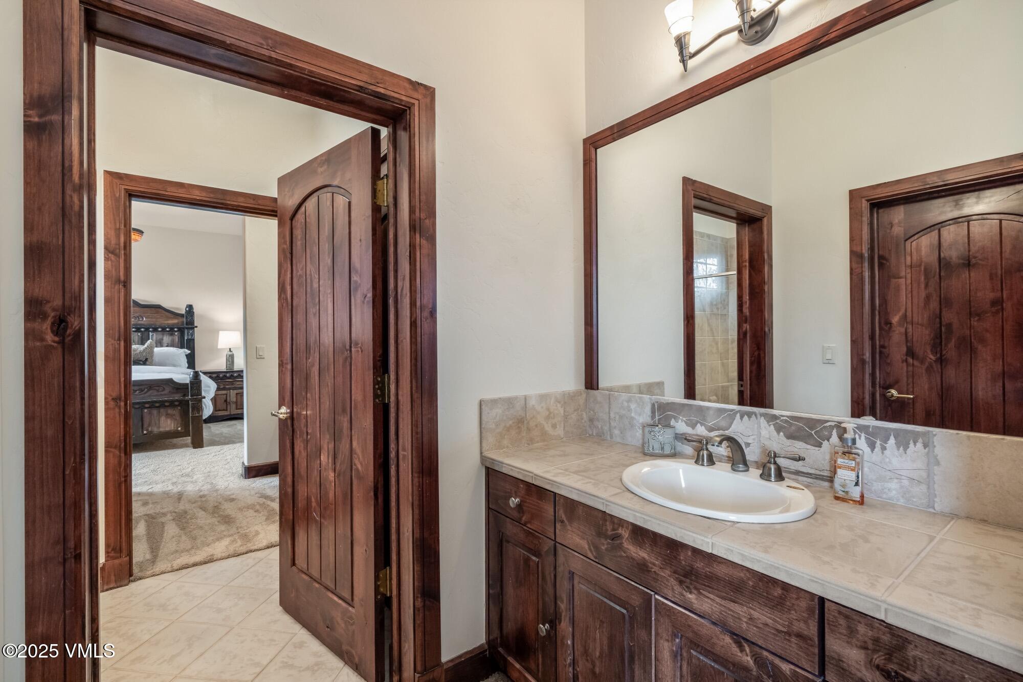 1122 Red Draw Edwards, CO 81632 - Photo 43 of 54 a en suite bathroom with a granite countertop sink and a mirror