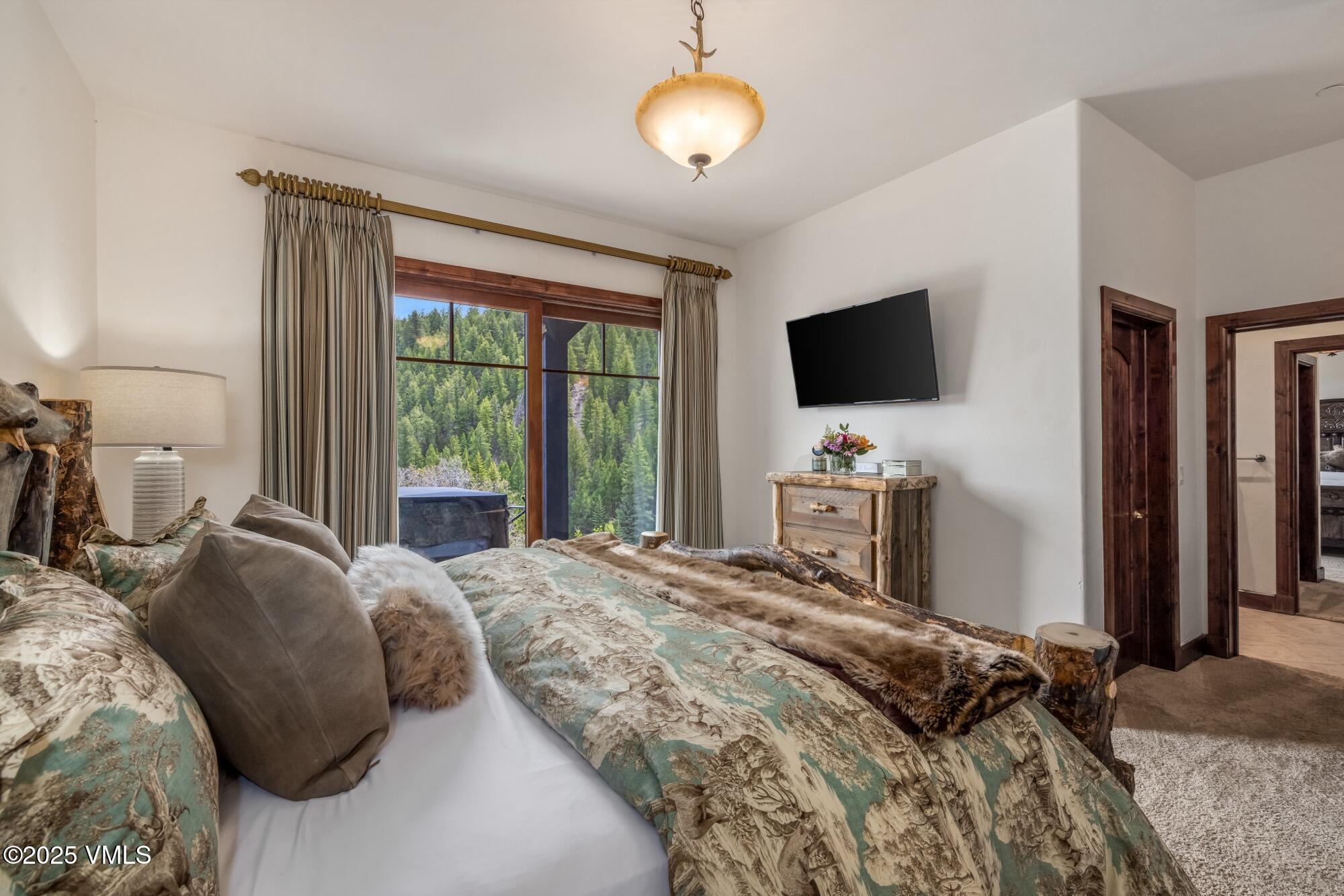 1122 Red Draw Edwards, CO 81632 - Photo 46 of 54 a bedroom with a bed and a flat tv screen on dresser