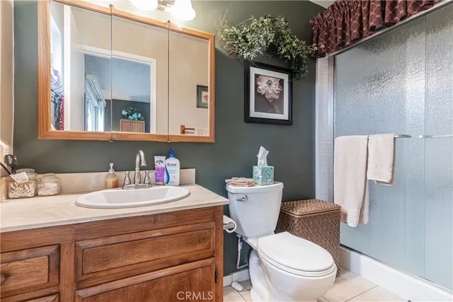 a bathroom with a toilet sink vanity and mirror