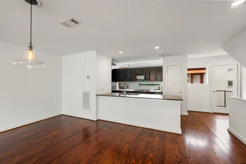 a view of kitchen with wooden floor and electronic appliances