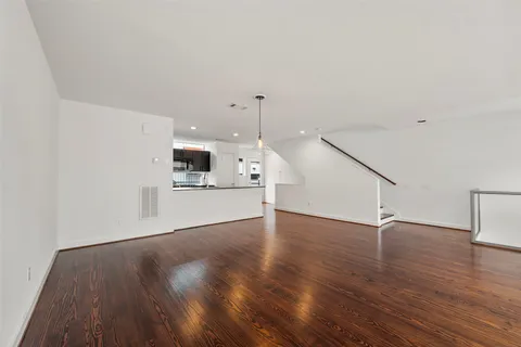a view of a kitchen with wooden floor and electronic appliances