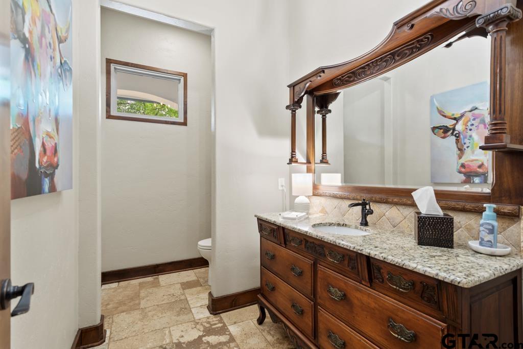 2907 Stewart Way Tyler, TX 75709 - Photo 25 of 45 a bathroom with a granite countertop sink and a mirror