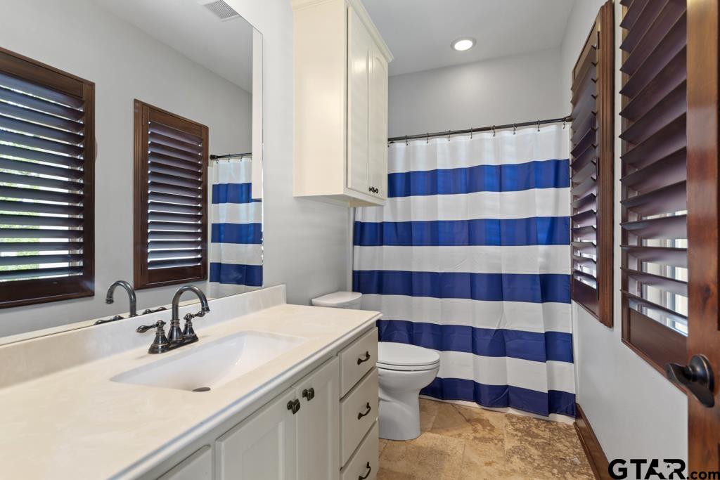 2907 Stewart Way Tyler, TX 75709 - Photo 29 of 45 a bathroom with a sink a toilet a mirror and shower