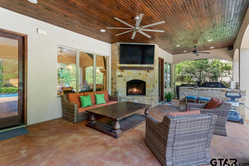 2907 Stewart Way Tyler, TX 75709 - Photo 30 of 45 a living room with furniture a fireplace and a floor to ceiling window