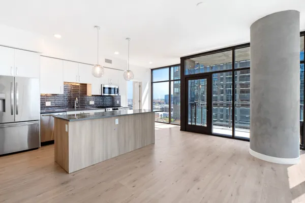 a kitchen with stainless steel appliances granite countertop a refrigerator a sink and a stove